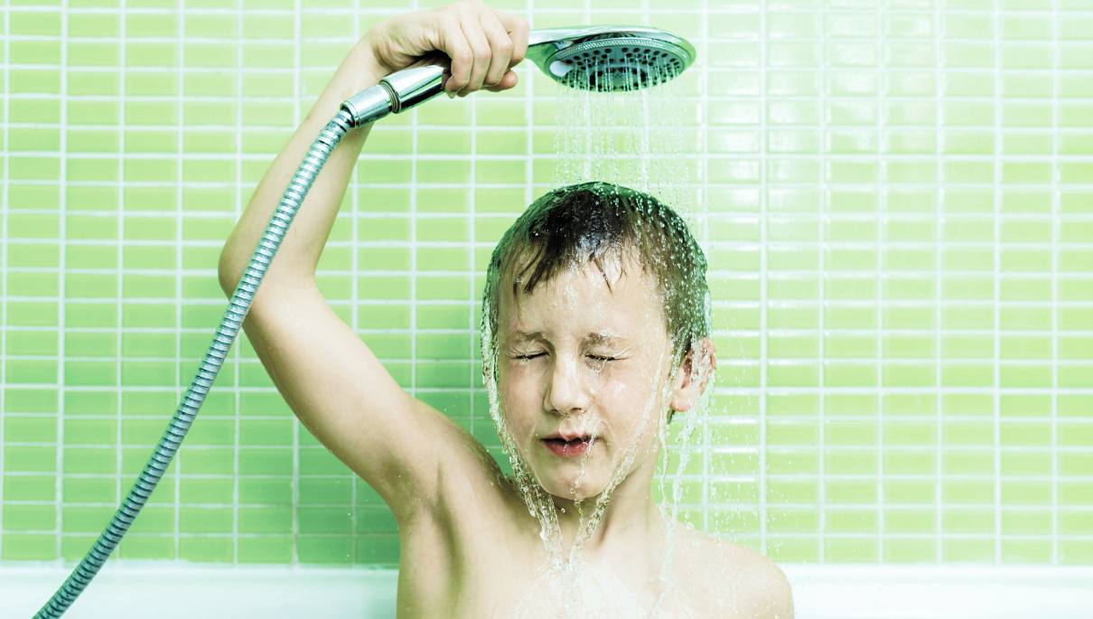 Un enfant qui prend une douche dans une baignoire