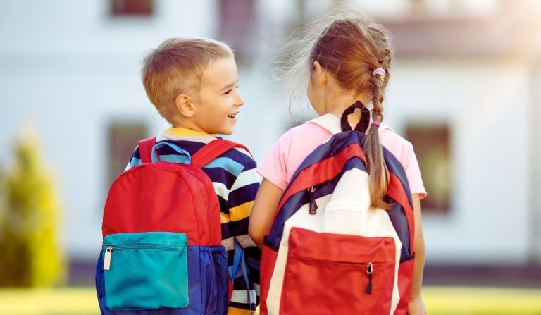 Deux enfants ( un garçon et une fille) de dos chacun avec un cartable
