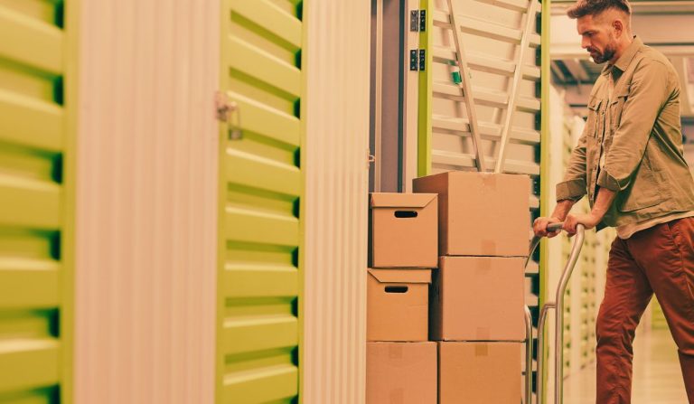 Un homme qui met des cartons dans un box de rangement