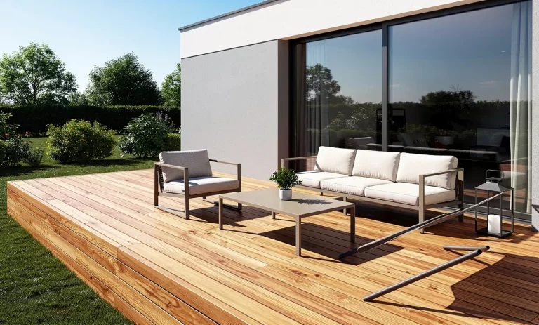 Terrasse en bois moderne attenante à une maison, meublée avec du mobilier extérieur minimaliste sous une lumière naturelle douce.